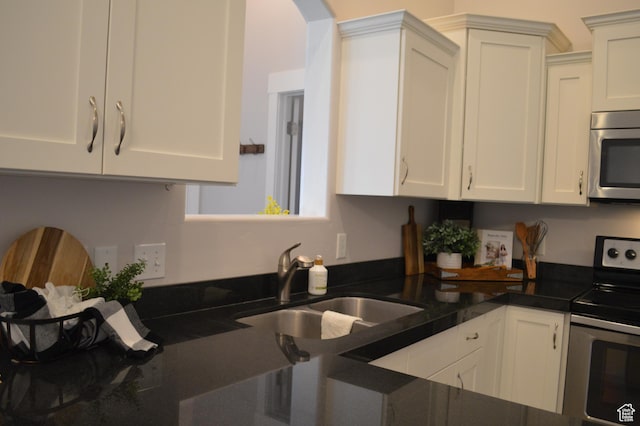 1921 N Crest Rd, Saratoga Springs, UT 84045 - kitchen with stainless steel appliances, a sink, white cabinets, and arched walkways