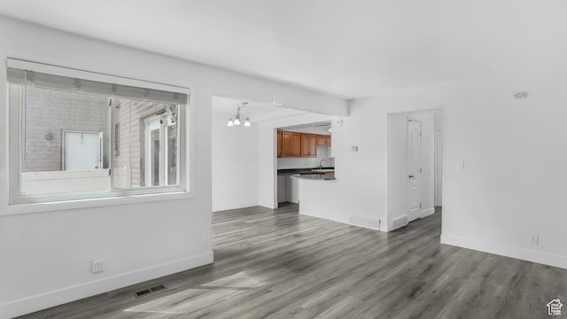 22 W La Vista Dr S, West Jordan, UT 84088 - unfurnished living room with an inviting chandelier, wood finished floors, visible vents, and a sink