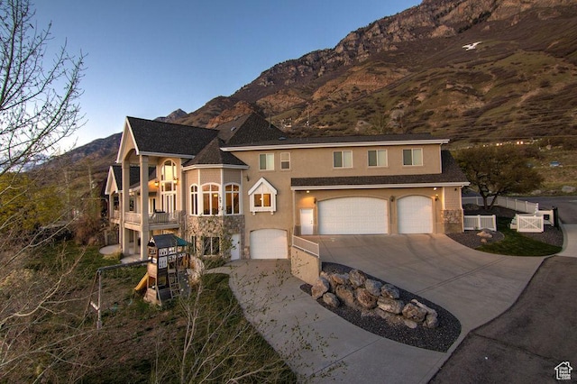 943 N Terrace Dr, Provo, UT 84604 - view of front of property featuring a balcony, driveway, an attached garage, a mountain view, and stucco siding