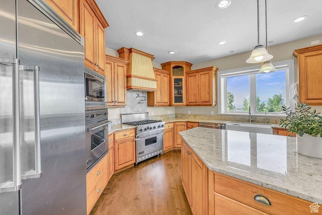 943 N Terrace Dr, Provo, UT 84604 - kitchen featuring wood finished floors, a sink, light stone countertops, glass insert cabinets, and built in appliances