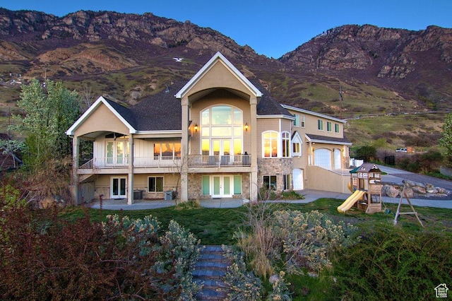 943 N Terrace Dr, Provo, UT 84604 - rear view of house with a playground, stone siding, french doors, an attached garage, and a mountain view