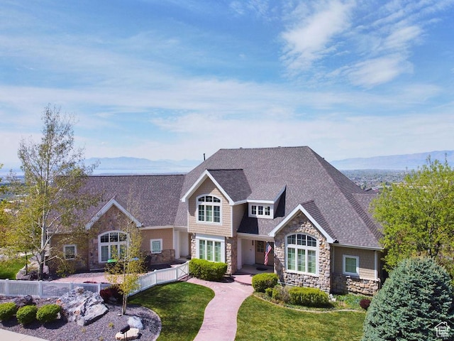 943 N Terrace Dr, Provo, UT 84604 - craftsman-style house featuring stone siding, a shingled roof, fence, a mountain view, and a front yard