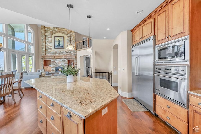 943 N Terrace Dr, Provo, UT 84604 - kitchen featuring arched walkways, dark wood finished floors, baseboards, built in appliances, and light stone countertops