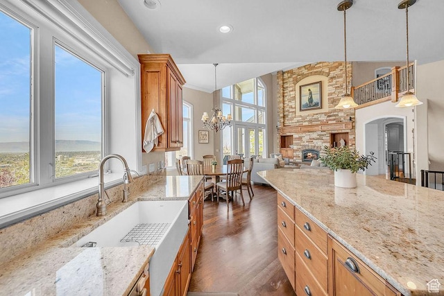943 N Terrace Dr, Provo, UT 84604 - kitchen featuring a sink, an inviting chandelier, pendant lighting, a high ceiling, and light stone countertops