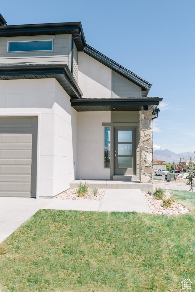 178 W Autumn Ln Unit 136, Saratoga Springs, UT 84045 - entrance to property with an attached garage, a yard, a mountain view, and stucco siding