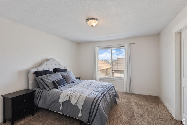 bedroom with a textured ceiling, visible vents, carpet flooring, and baseboards