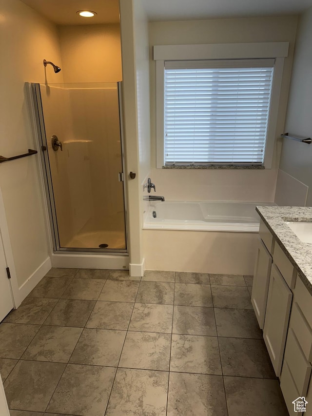 full bathroom featuring a shower stall, a garden tub, vanity, and tile patterned floors