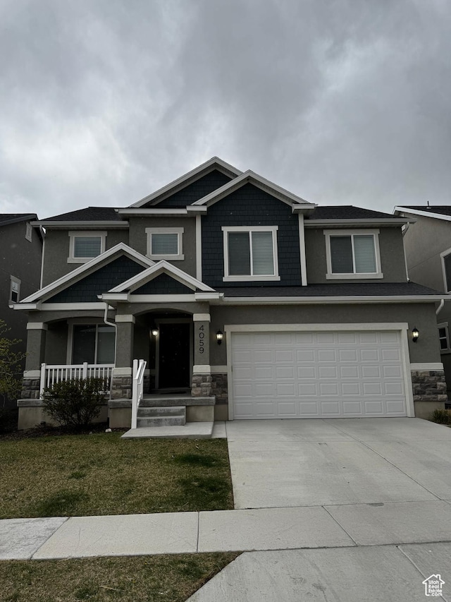 craftsman-style home with driveway, stone siding, a porch, a garage, and stucco siding