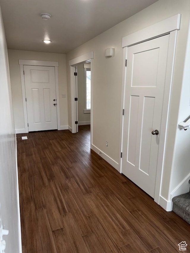 interior space with stairs, baseboards, and dark wood-style flooring