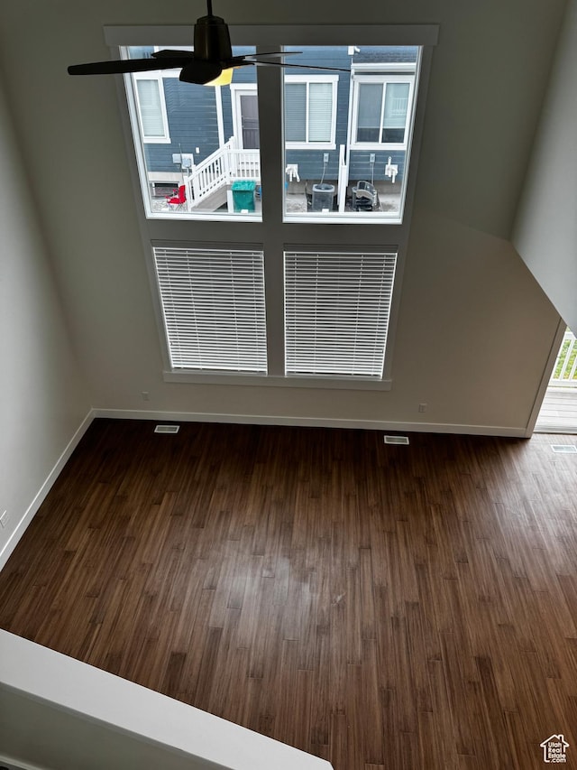 unfurnished dining area featuring wood finished floors, a ceiling fan, and baseboards