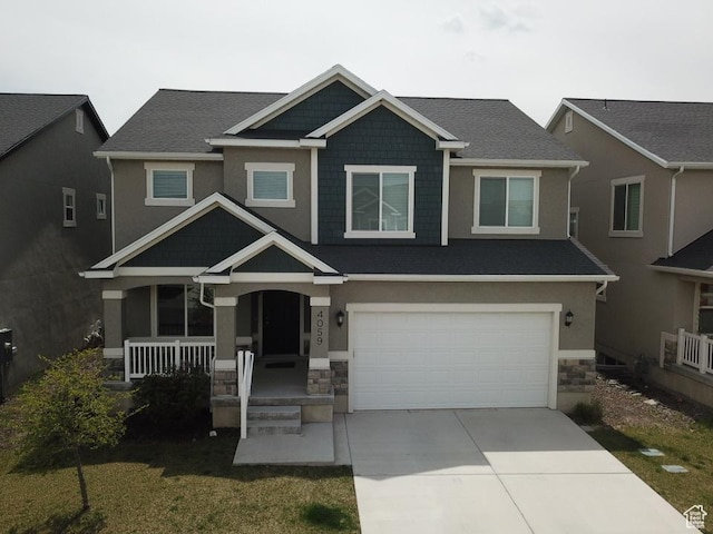 craftsman-style home featuring concrete driveway, a porch, stone siding, and a garage