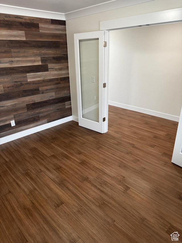 empty room featuring baseboards and dark wood-style flooring