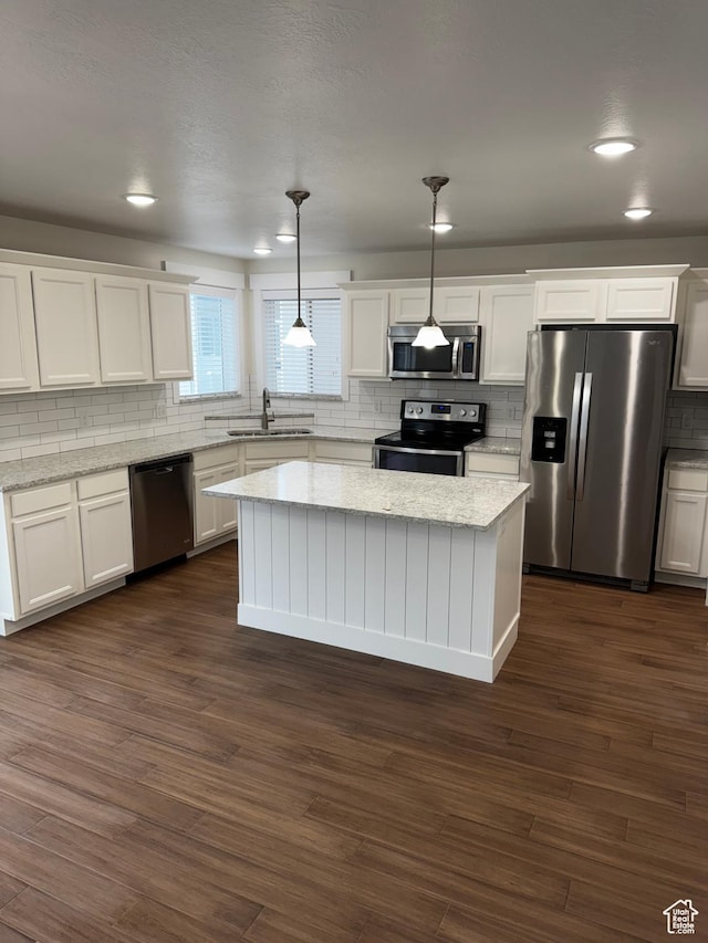 kitchen with white cabinets, stainless steel appliances, a sink, and tasteful backsplash