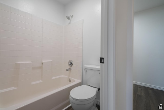 bathroom featuring tub / shower combination, wood finished floors, toilet, and baseboards