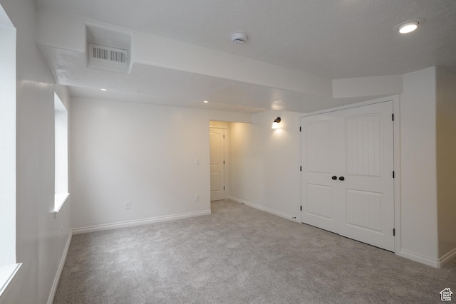 below grade area featuring recessed lighting, carpet, visible vents, and baseboards