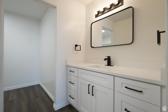 bathroom featuring baseboards, wood finished floors, and vanity