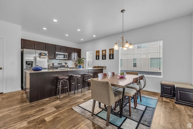 14714 S Rising Star Way, Bluffdale, UT 84065 - dining space featuring baseboards, wood finished floors, recessed lighting, and a chandelier