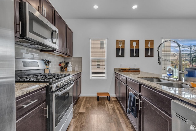 14714 S Rising Star Way, Bluffdale, UT 84065 - kitchen featuring stainless steel appliances, a sink, dark brown cabinets, light stone countertops, and dark wood-type flooring
