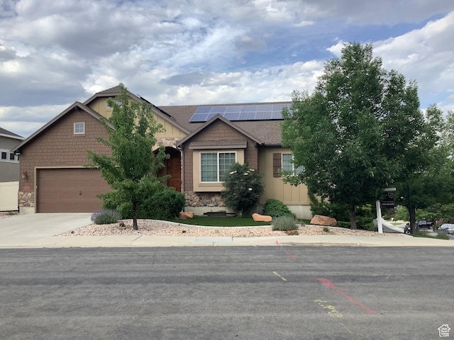 14757 S Quiet Glen Dr, Herriman, UT 84096 - view of front of house featuring solar panels, driveway, stone siding, and an attached garage
