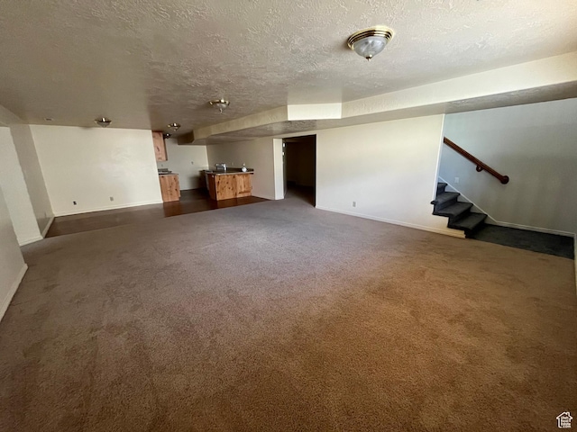 407 W Larkspur Ln, Morgan, UT 84050 - unfurnished living room featuring dark colored carpet, baseboards, a textured ceiling, and stairway