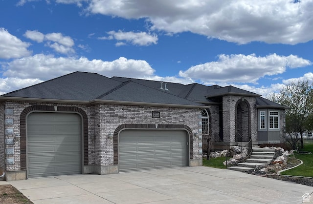 view of front of property with a garage, driveway, a shingled roof, and brick siding