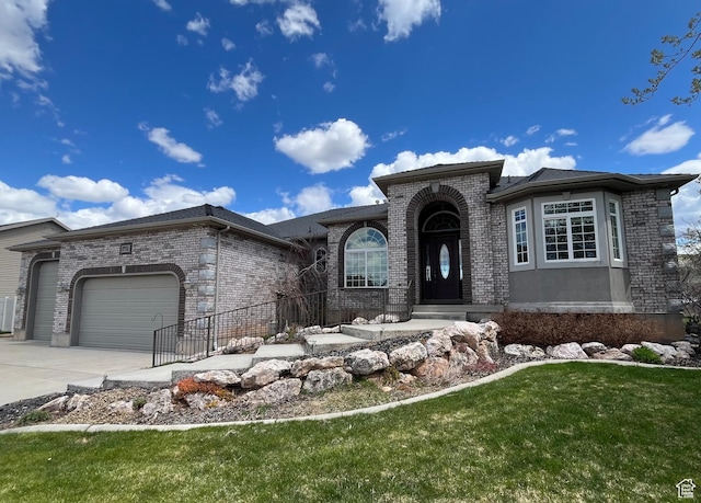 407 W Larkspur Ln, Morgan, UT 84050 - view of front of house featuring an attached garage, a front lawn, driveway, and brick siding