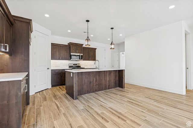 3618 W 185 N, Hurricane, UT 84737 - kitchen featuring light countertops, dark brown cabinets, light wood-style floors, and appliances with stainless steel finishes