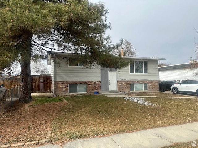 4584 S Knightsbridge Rd, Taylorsville, UT 84129 - split foyer home with fence, brick siding, and a front yard