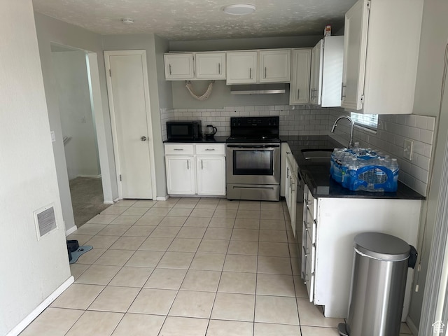 4584 S Knightsbridge Rd, Taylorsville, UT 84129 - kitchen with dark countertops, a sink, black microwave, stainless steel range with electric stovetop, and white cabinets