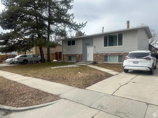4584 S Knightsbridge Rd, Taylorsville, UT 84129 - split foyer home with brick siding, concrete driveway, and fence