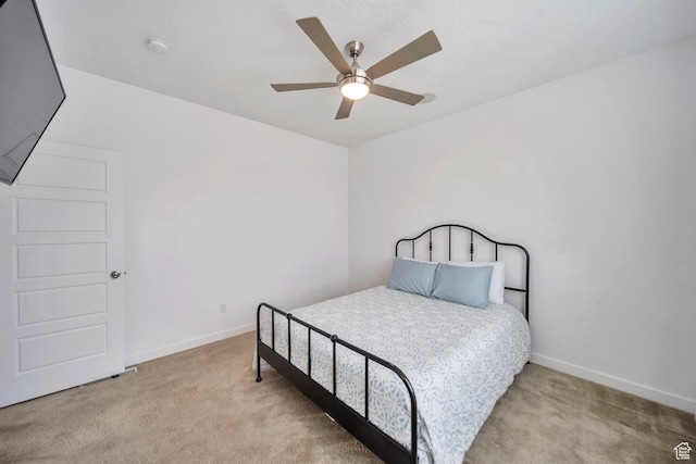 carpeted bedroom featuring baseboards and a ceiling fan