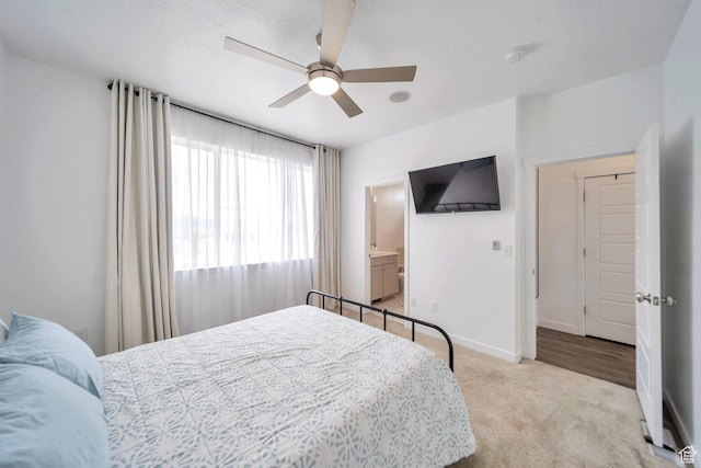bedroom with connected bathroom, ceiling fan, carpet floors, and baseboards