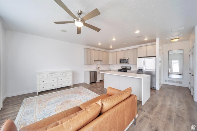 kitchen with light countertops, visible vents, a ceiling fan, a center island, and appliances with stainless steel finishes