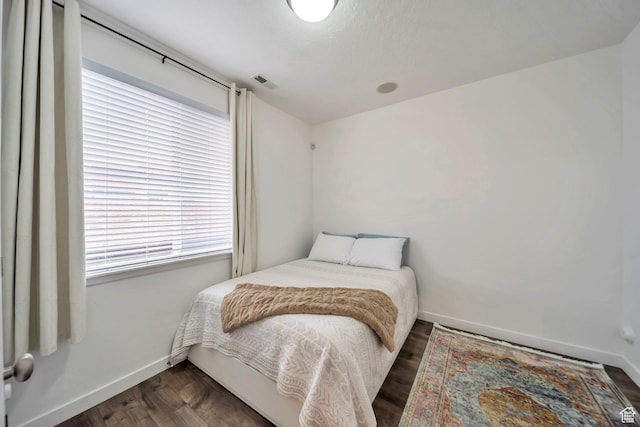 bedroom featuring dark wood-style floors, baseboards, and visible vents