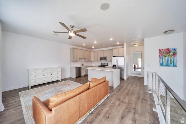 living area featuring a ceiling fan, wood finished floors, baseboards, visible vents, and recessed lighting