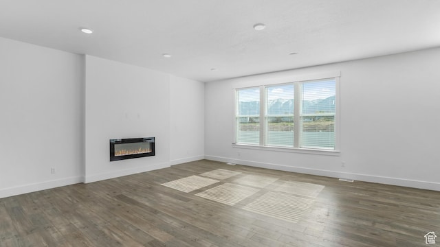 794 Brook Ave E, Tooele, UT 84074 - unfurnished living room with a glass covered fireplace, wood finished floors, baseboards, and heating unit