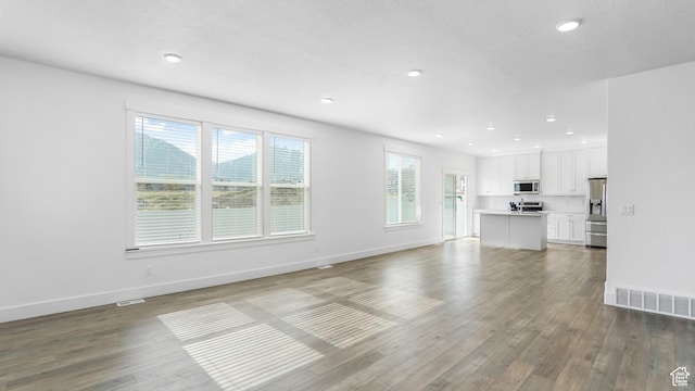 794 Brook Ave E, Tooele, UT 84074 - unfurnished living room with baseboards, wood finished floors, visible vents, and recessed lighting