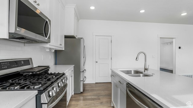 794 Brook Ave E, Tooele, UT 84074 - kitchen with tasteful backsplash, a sink, light wood-type flooring, white cabinetry, and appliances with stainless steel finishes