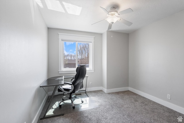 office featuring a skylight, baseboards, and a ceiling fan
