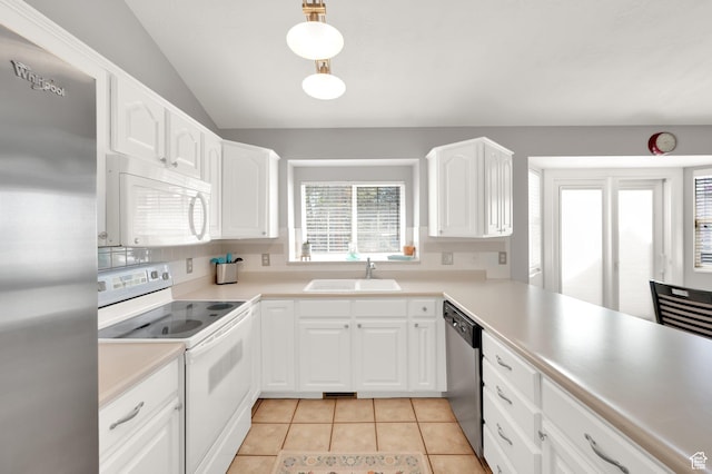 kitchen featuring a sink, stainless steel appliances, light countertops, lofted ceiling, and white cabinetry