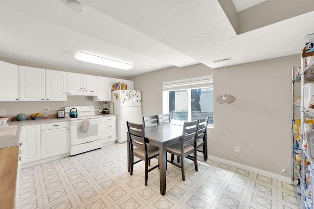 kitchen with white cabinetry, under cabinet range hood, white appliances, and light countertops