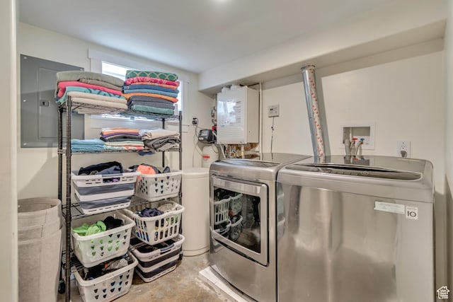 clothes washing area with water heater, electric panel, washer and dryer, and laundry area