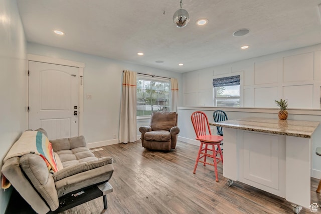 living room with light wood-type flooring, baseboards, and recessed lighting
