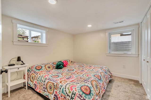 carpeted bedroom with baseboards, visible vents, recessed lighting, and a closet