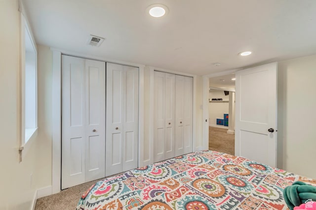 bedroom featuring multiple closets, carpet, baseboards, visible vents, and recessed lighting
