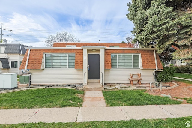 bungalow featuring entry steps and a front lawn