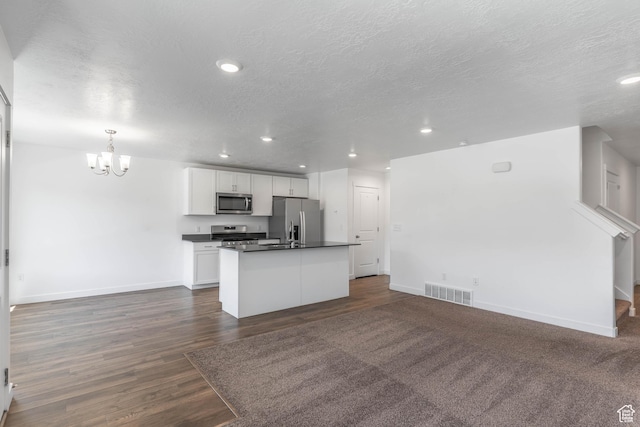 kitchen featuring dark countertops, visible vents, appliances with stainless steel finishes, and open floor plan