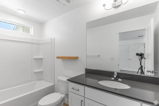 bathroom featuring toilet, vanity, and bathtub / shower combination