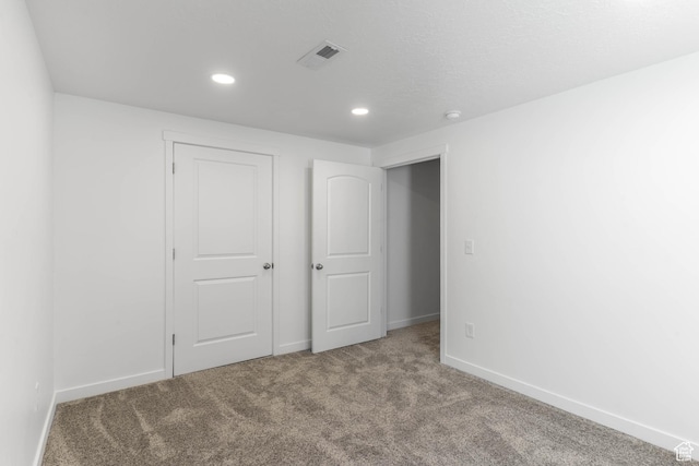 unfurnished bedroom with recessed lighting, baseboards, visible vents, and carpet