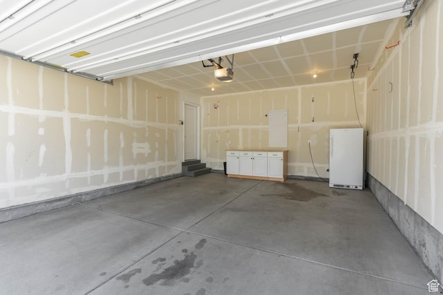 garage with a garage door opener and freestanding refrigerator